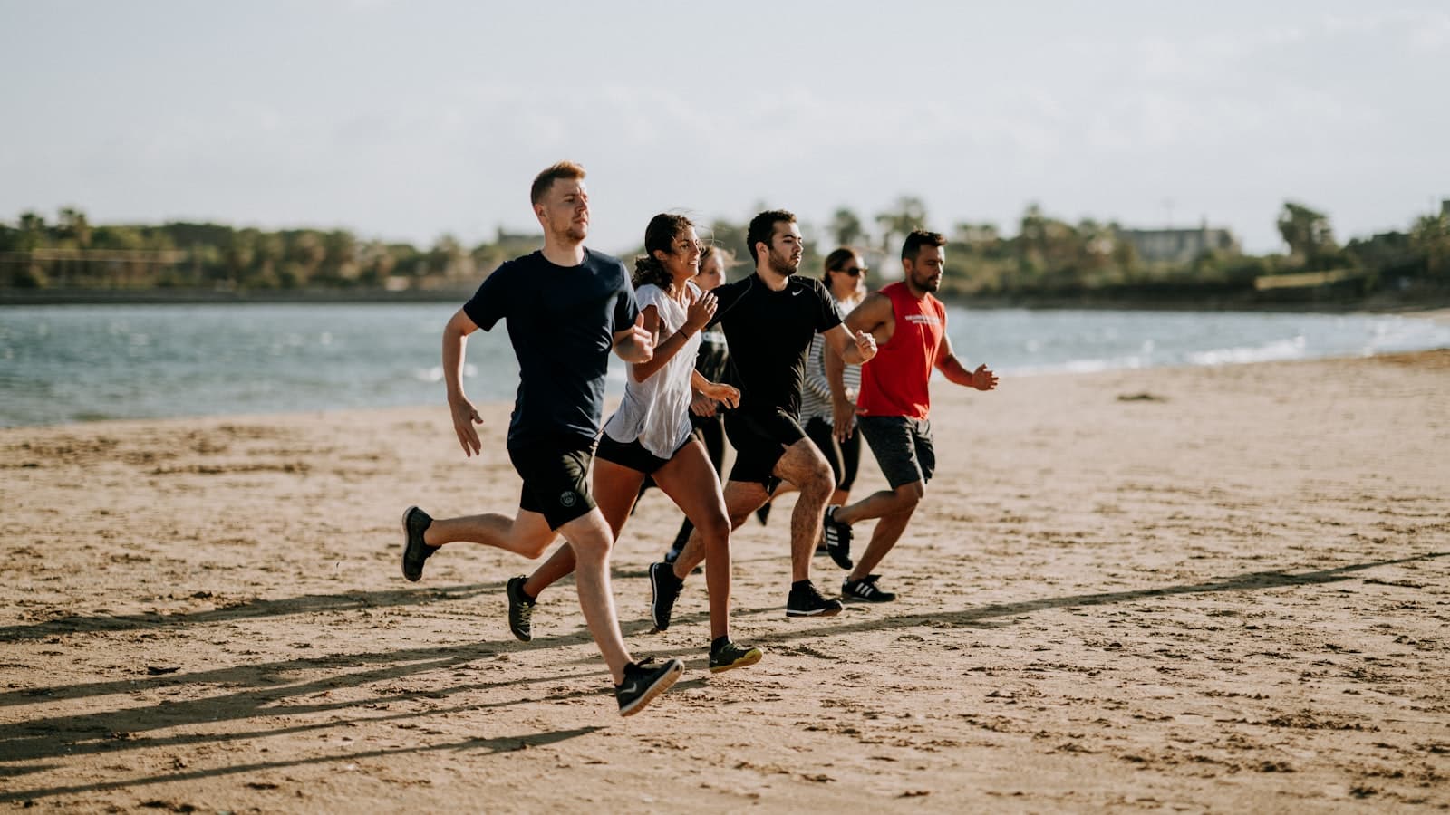 A diverse group of men and women running together outdoors